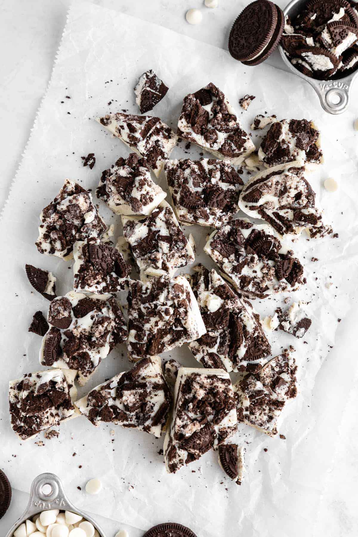 a pile of white chocolate cookies and cream bark on parchment paper