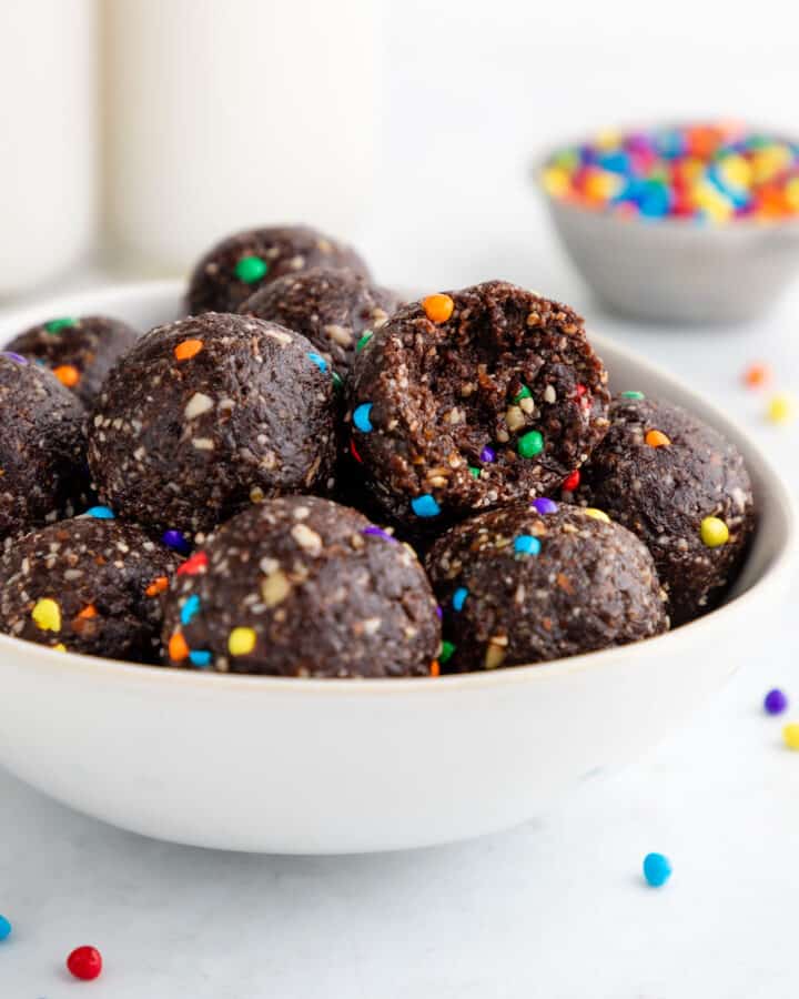 a bowl of healthy cosmic brownie bites with a bite taken out of one