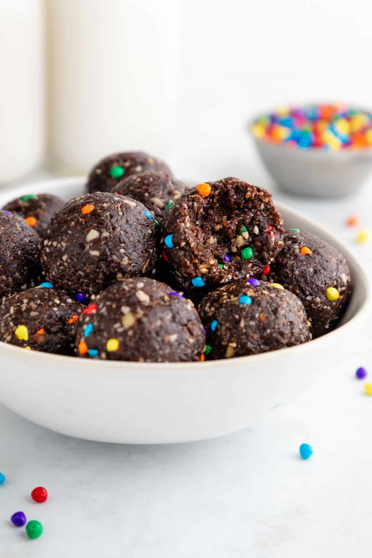 a bowl of healthy cosmic brownie bites with a bite taken out of one