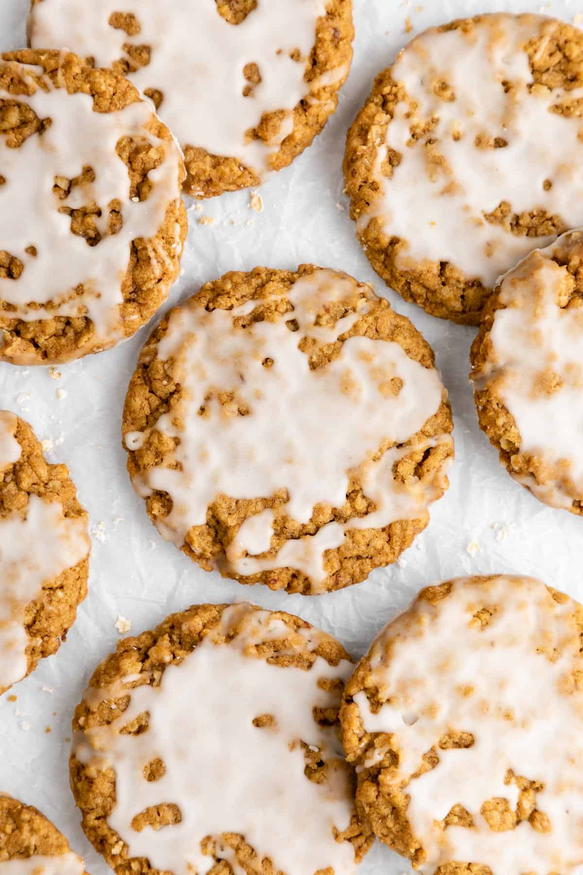 a pile of vegan iced oatmeal cookies with vanilla frosting