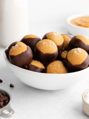 a white bowl filled with healthy buckeyes