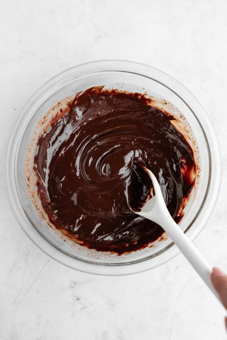 mixing vegan peppermint chocolate ganache inside a glass mixing bowl