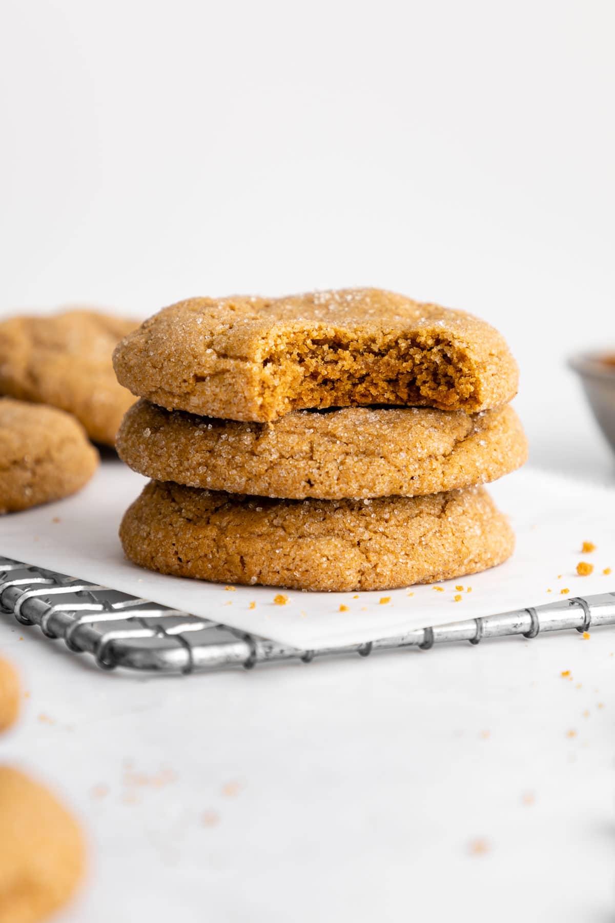 a stack of vegan brown sugar cookies with a bite taken out of the top one