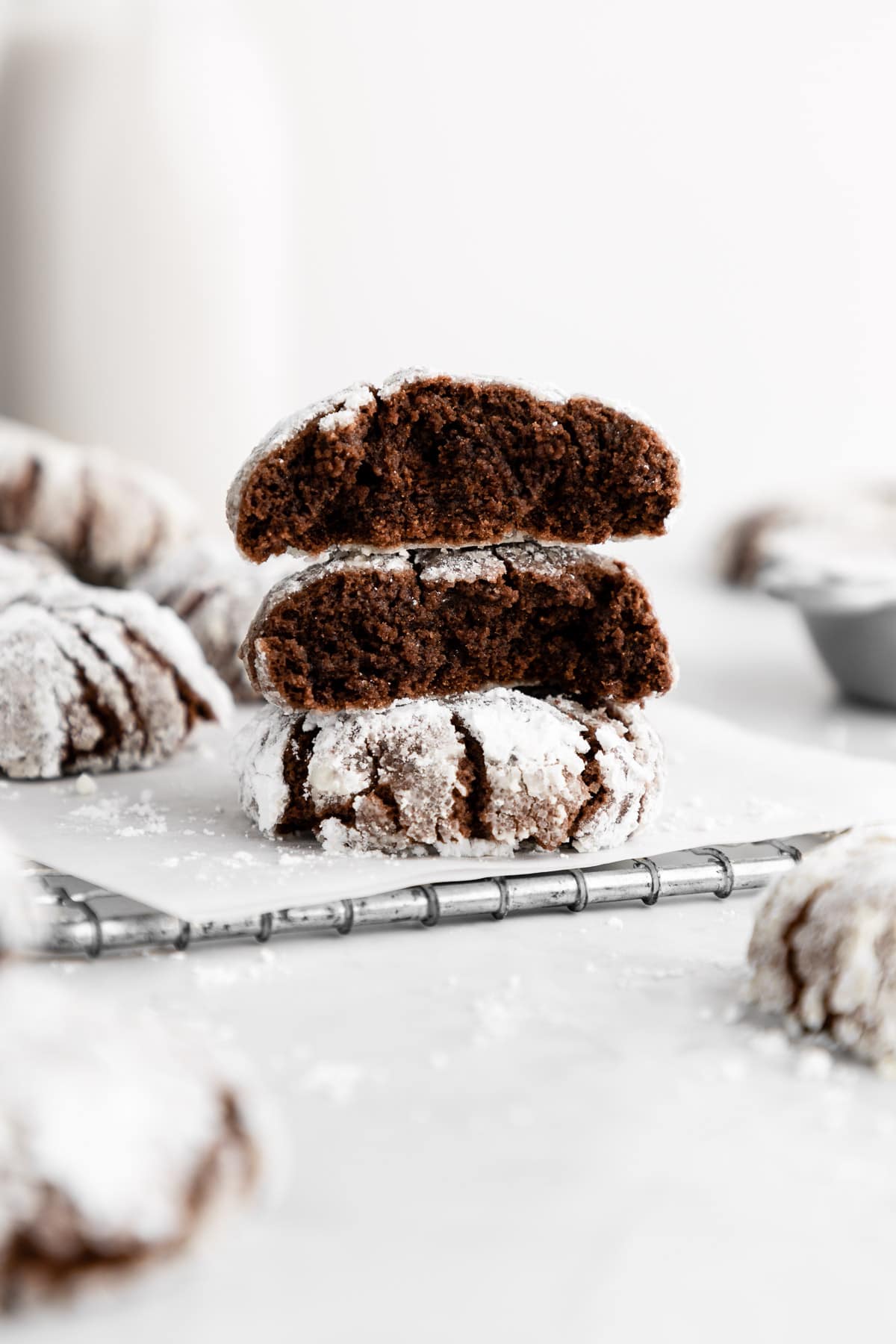 a stack of vegan chocolate crinkle cookies cut in half showing the cross section