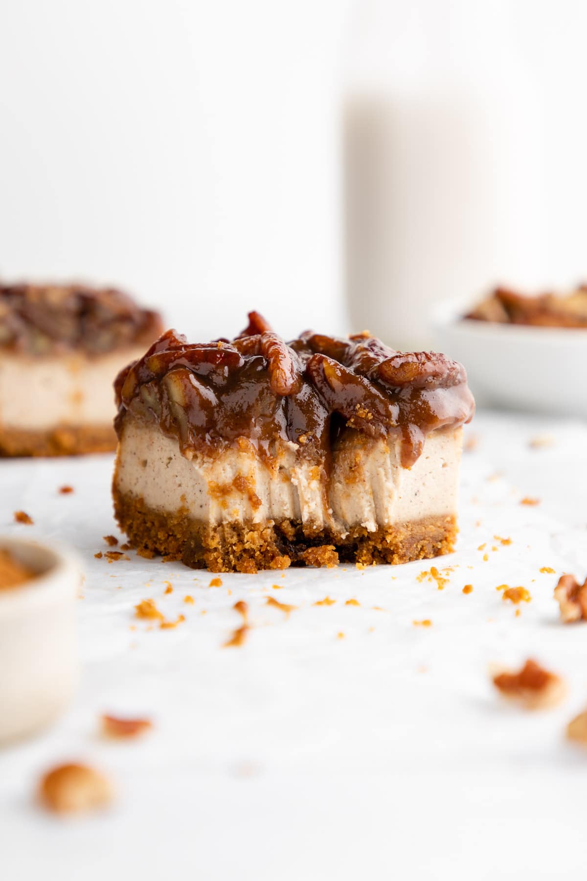 a vegan pecan pie cheesecake bar with a bite taken out of it