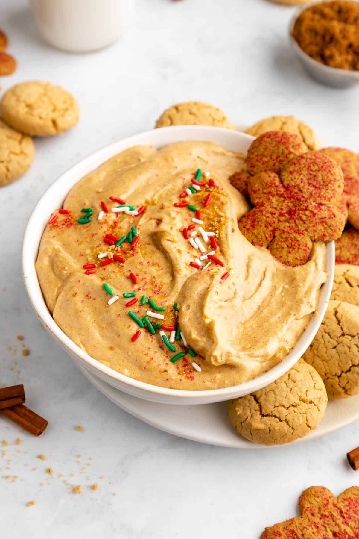 vegan gingerbread cookie dip in a bowl with sprinkles and Christmas cookies