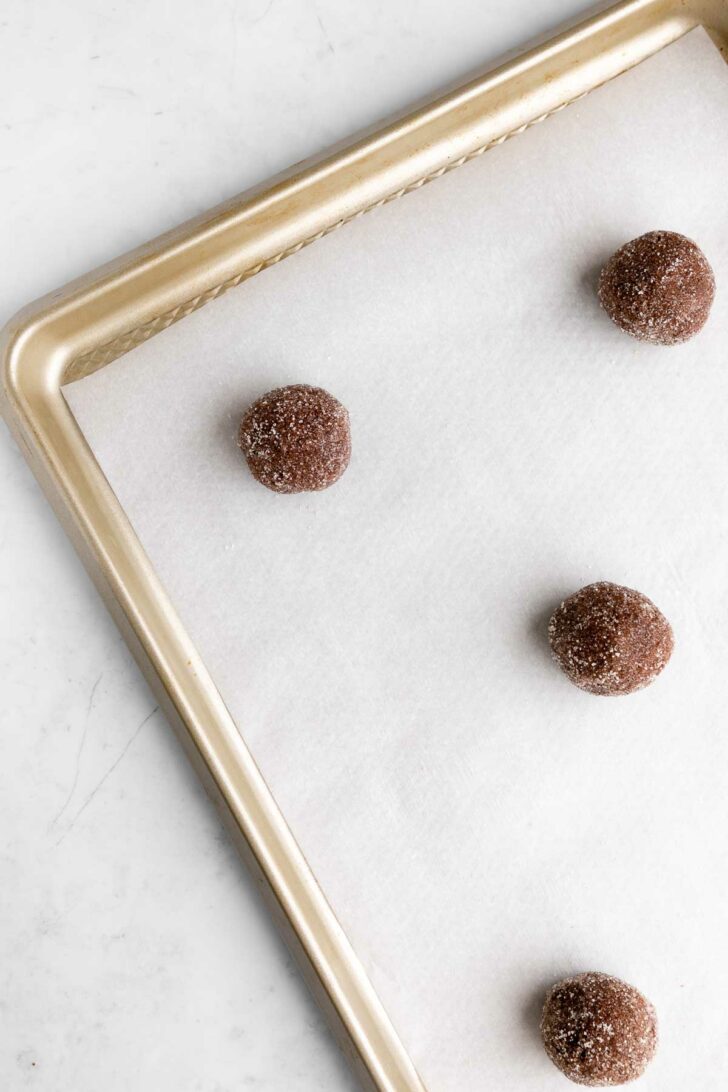 balls of vegan chocolate sugar cookie dough on a baking sheet
