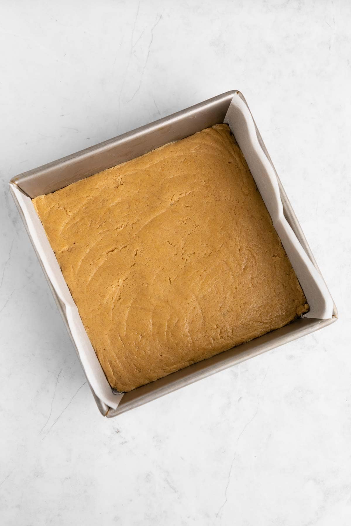 vegan cinnamon roll blondies dough in a square baking dish