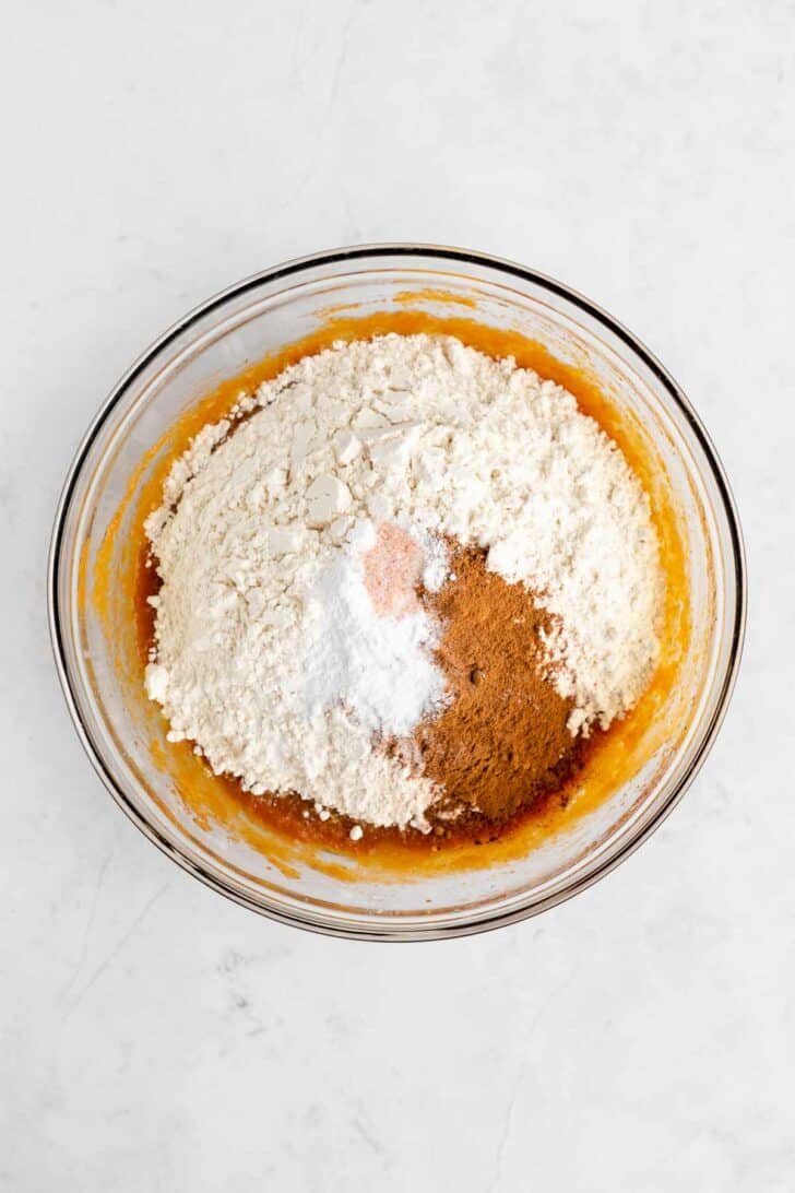 ingredients for vegan pumpkin cake inside a glass mixing bowl
