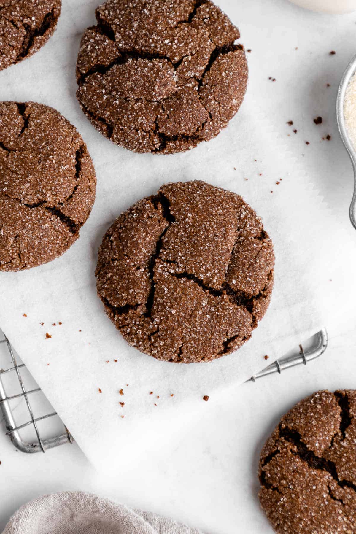 a close up of vegan chocolate sugar cookies on a wire cooling rack