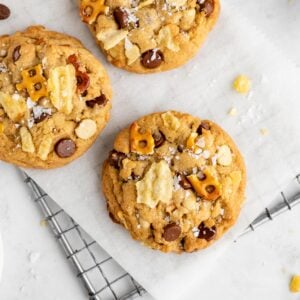 a close up of vegan kitchen sink cookies with chocolate chips, potato chips, pretzels, and butterscotch chips