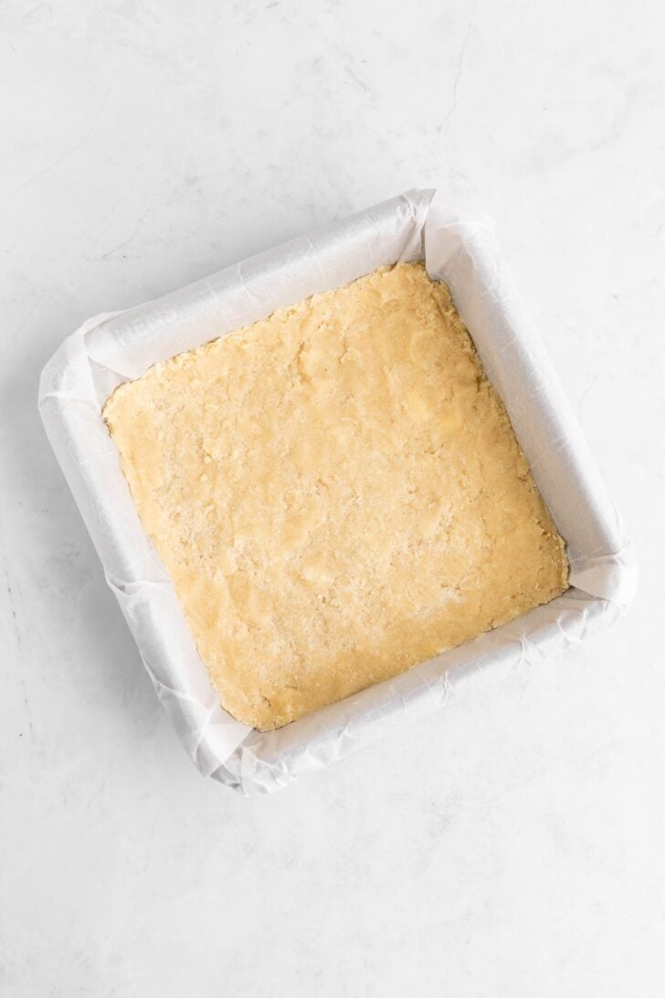 vegan shortbread cookie dough pressed into a square baking dish