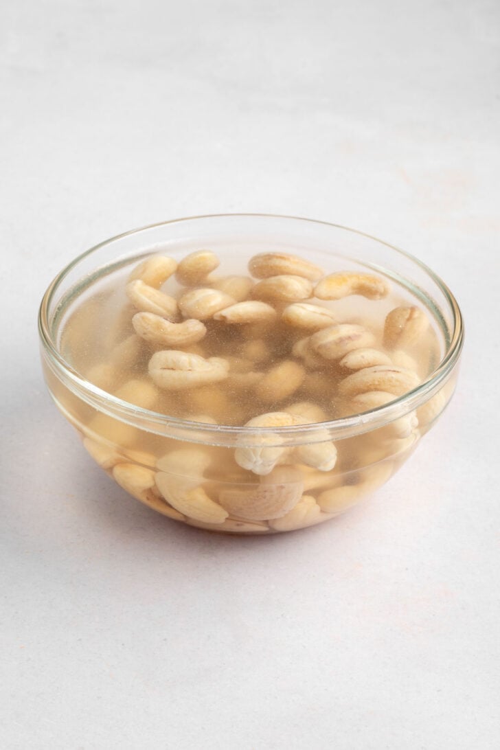 raw cashews soaking in water inside a glass pyrex bowl