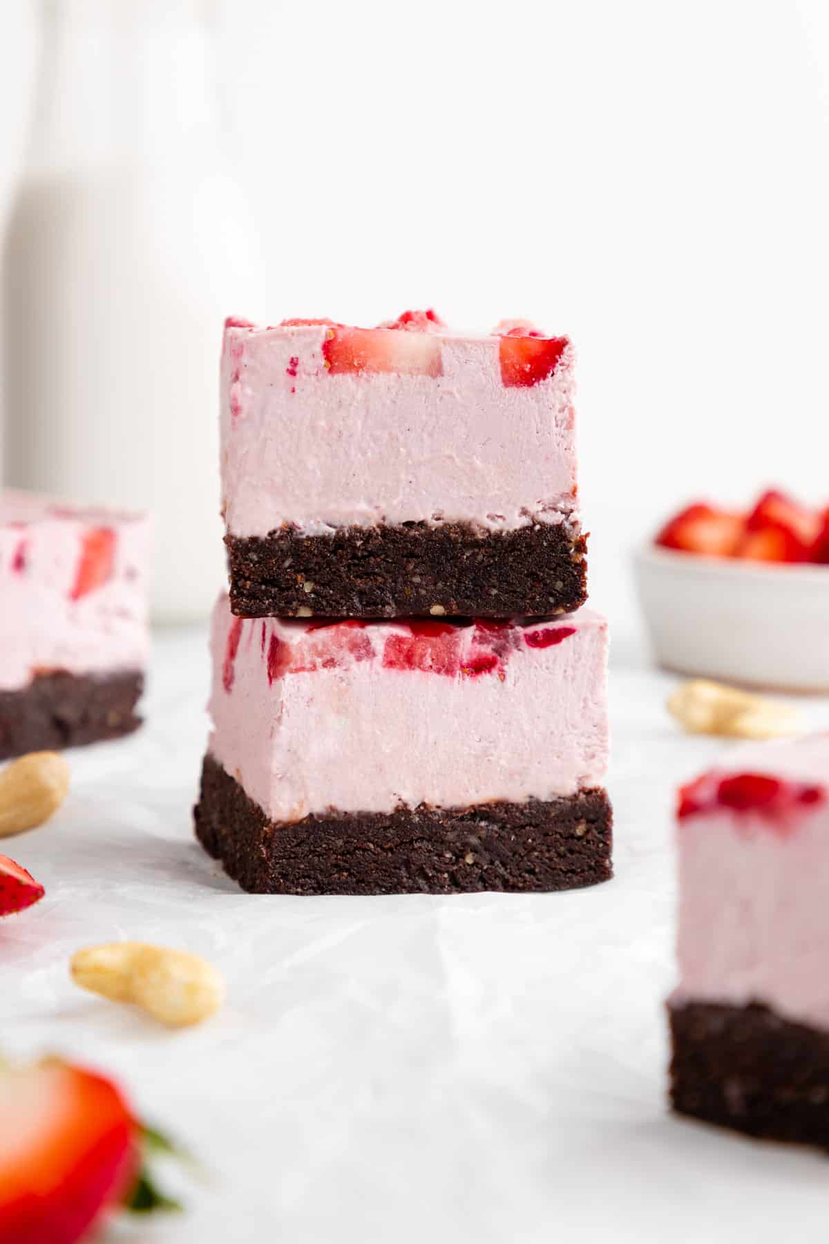 a stack of two no-bake strawberry cheesecake brownies with dates and cashews