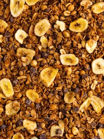 close up photo of homemade chunky monkey granola with banana chips, nuts, coconut, and chocolate chips
