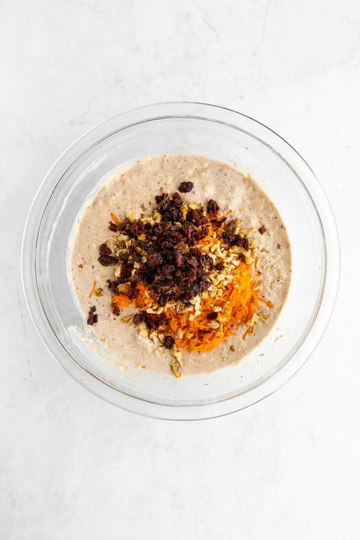 vegan carrot cake pancake batter with raisins and walnuts in a glass bowl