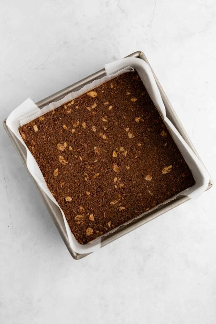 vegan mint nanaimo bars crust inside a square baking dish