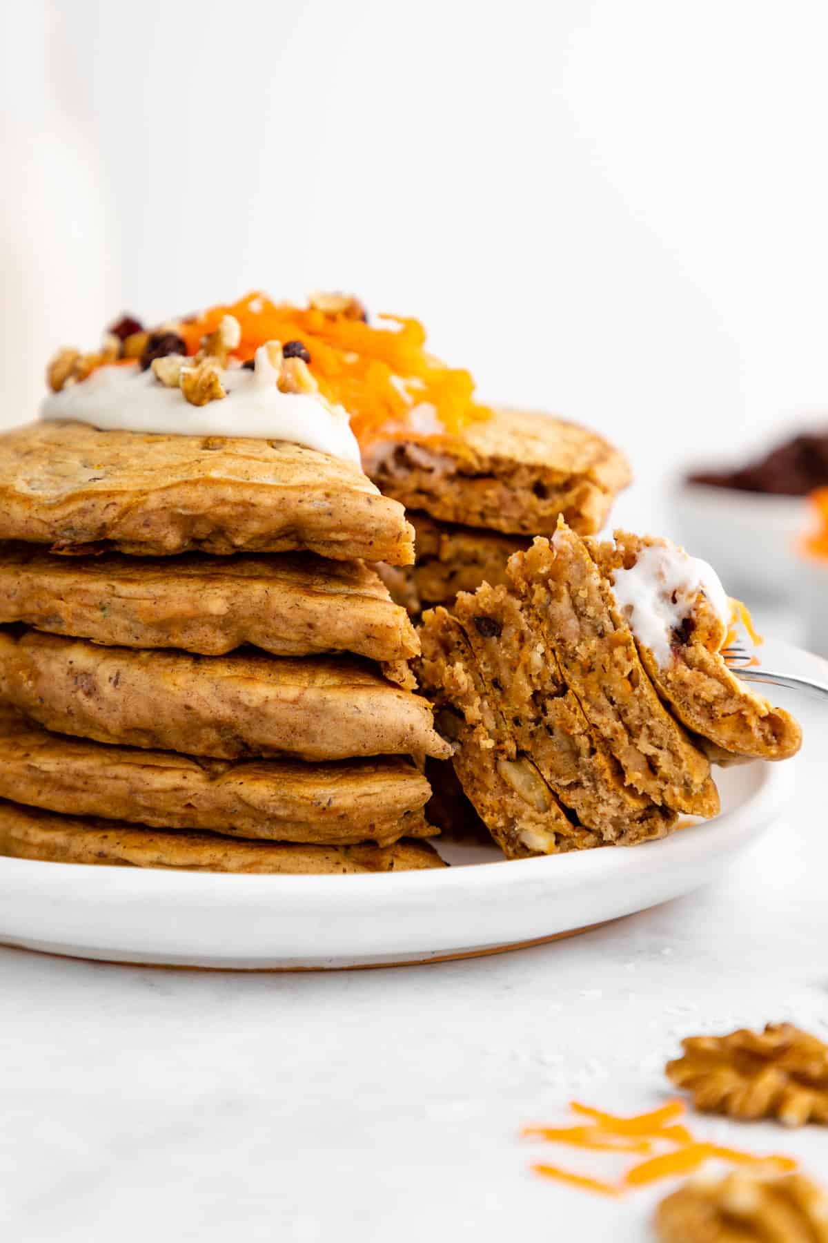 a fork digging into a stack of vegan carrot cake pancakes