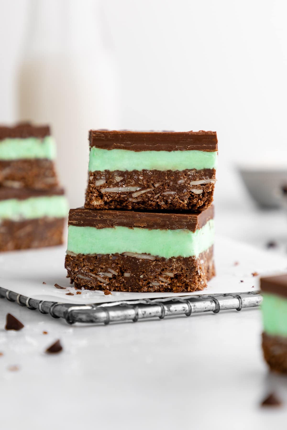 a stack of two vegan mint nanaimo bars with mint buttercream frosting