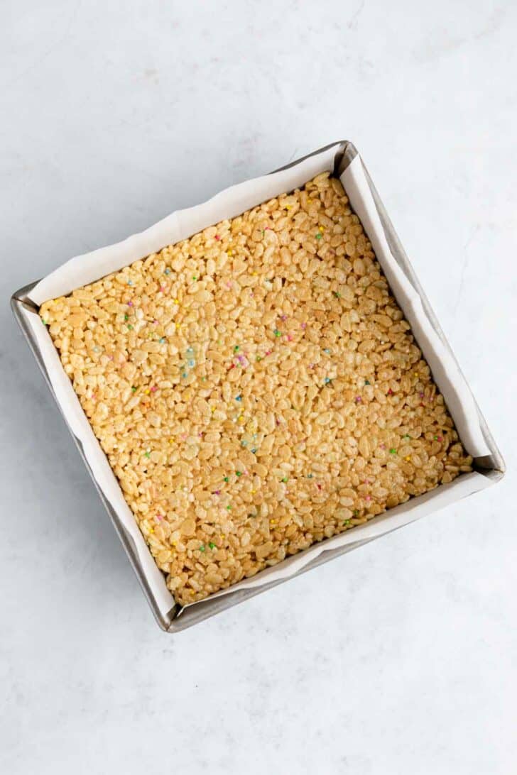 birthday cake rice krispie treats inside a square baking pan