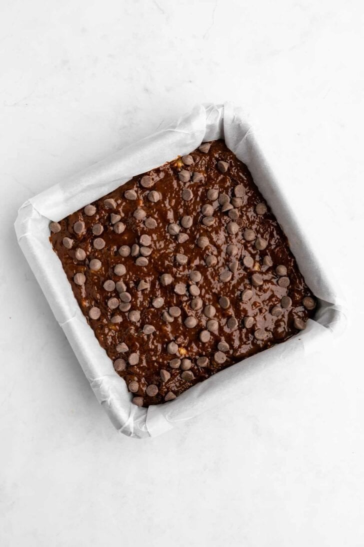 unbaked vegan banana brownies batter inside a square baking pan