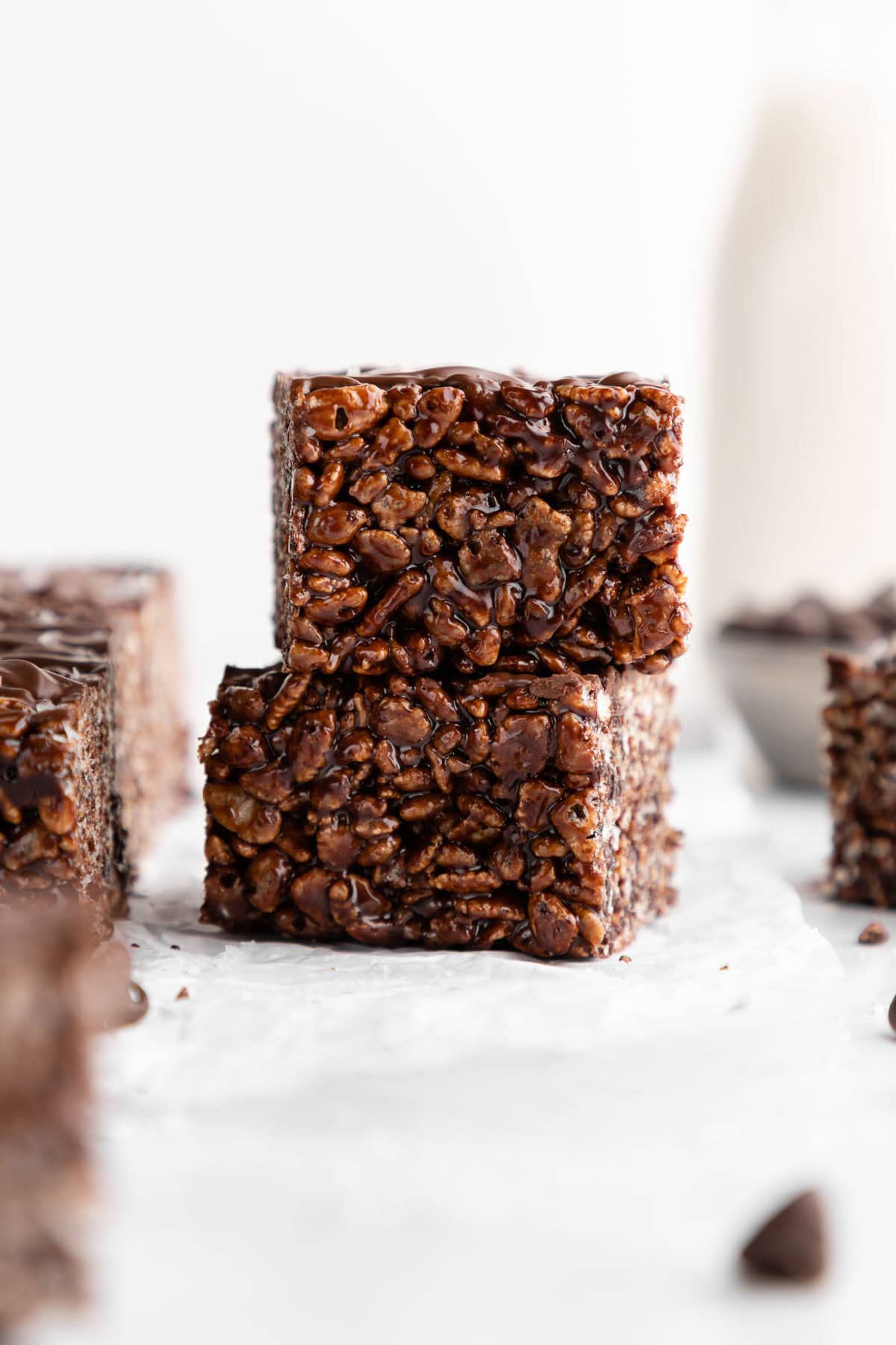 a stack of two vegan chocolate rice krispie treats with chocolate chips and marshmallows