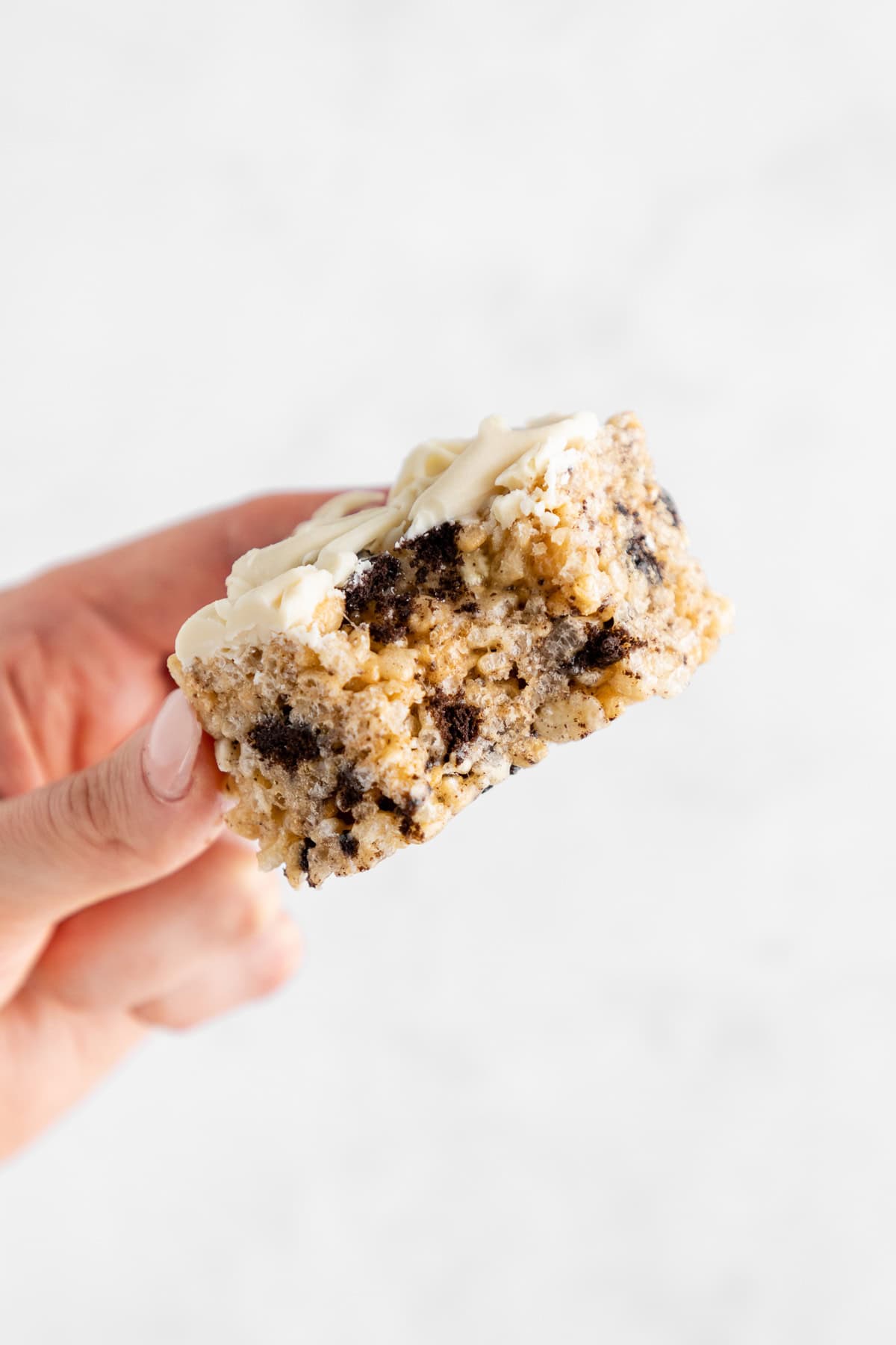 a hand holding a vegan oreo rice krispie treat