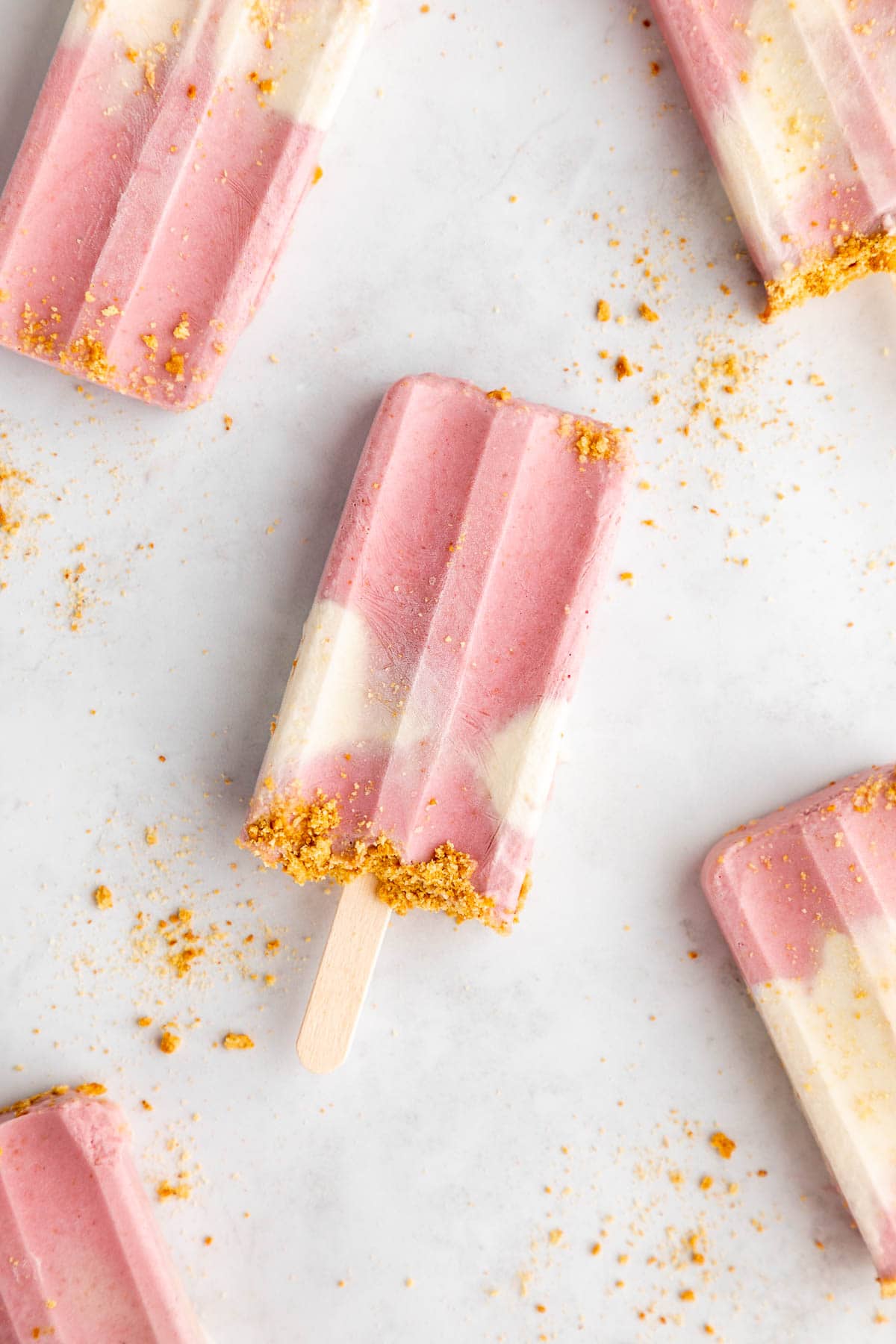 vegan strawberry cheesecake popsicles with graham cracker crumbs