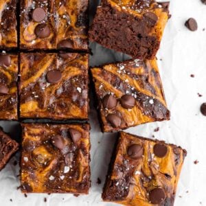 a pile of sliced vegan pumpkin cheesecake brownies