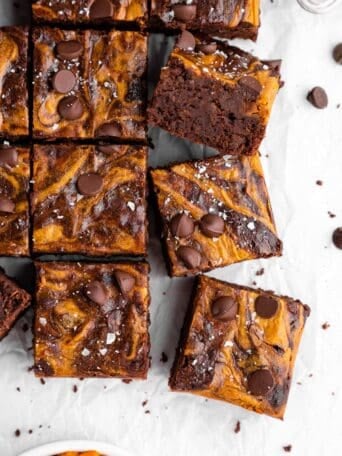 a pile of sliced vegan pumpkin cheesecake brownies