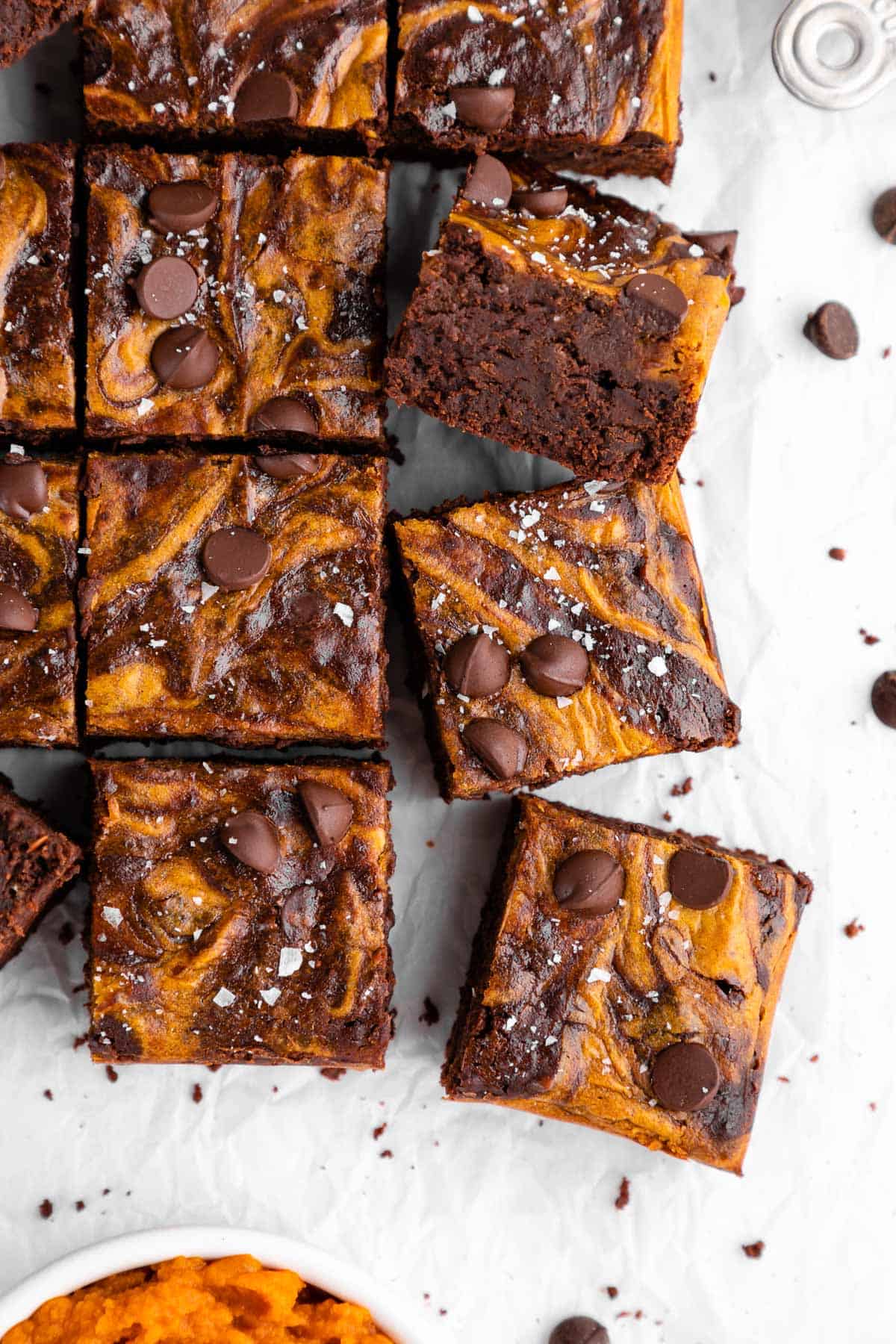 a pile of sliced vegan pumpkin cheesecake brownies