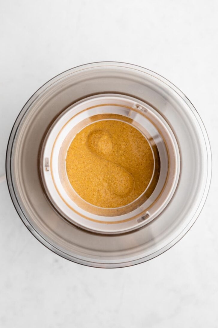 churning vegan pumpkin ice cream inside a cuisinart ice cream maker
