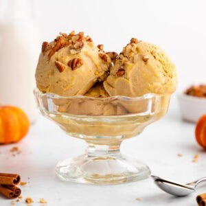 vegan pumpkin ice cream scoops inside a glass sundae bowl