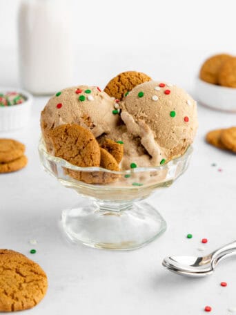 scoops of vegan gingerbread ice cream with gingersnap cookies inside a sundae glass