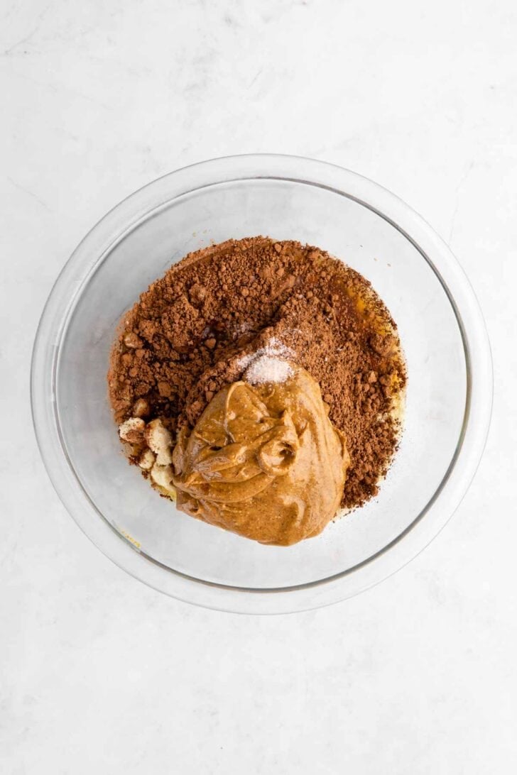 almond flour, almond butter, cocoa powder, and maple syrup in a glass bowl