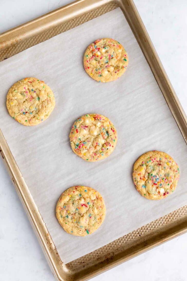 vegan birthday cake cookies with white chocolate chips and sprinkles on a baking sheet