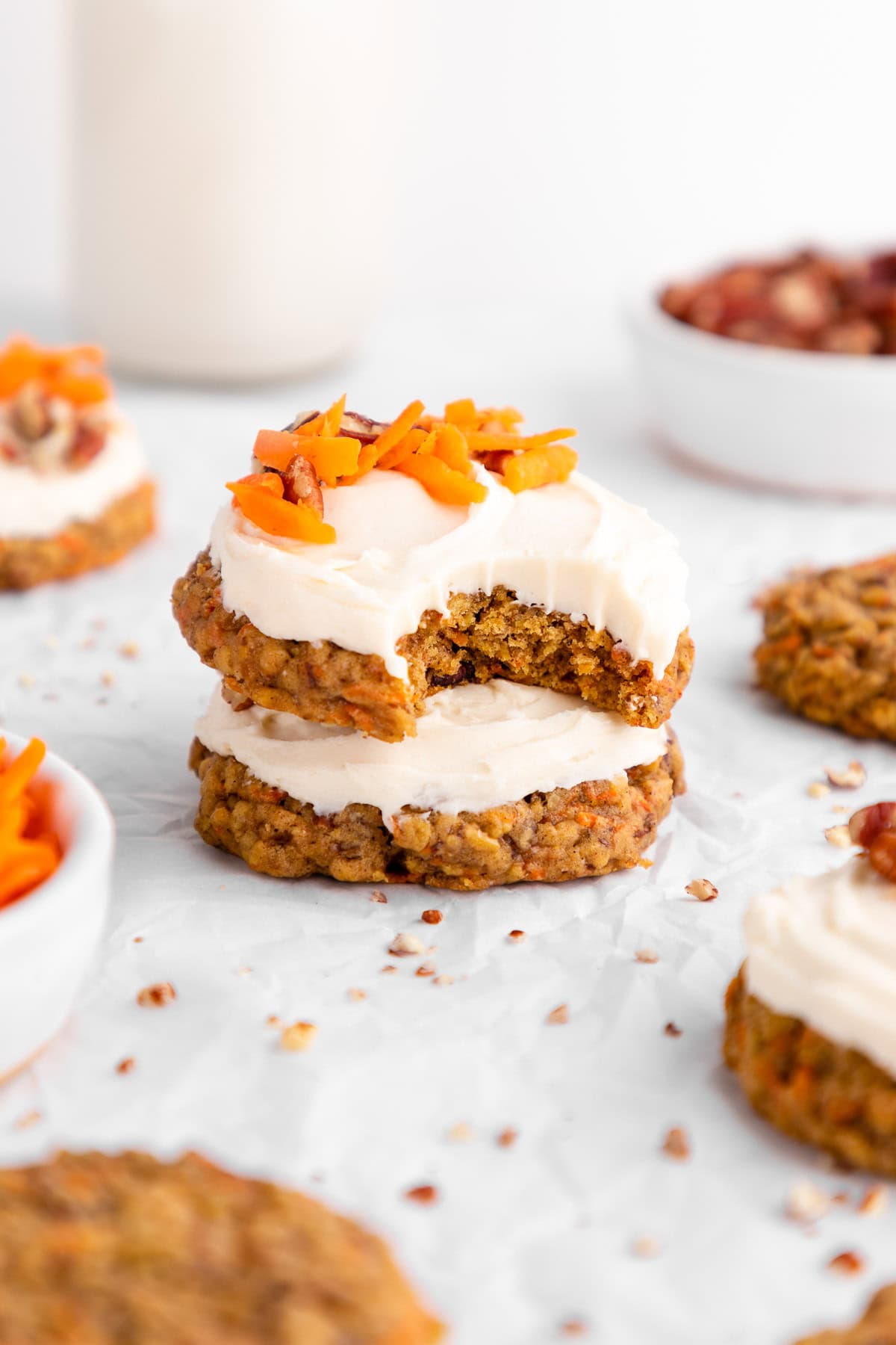 a stack of vegan carrot cake cookies with a bite taken out of the top one