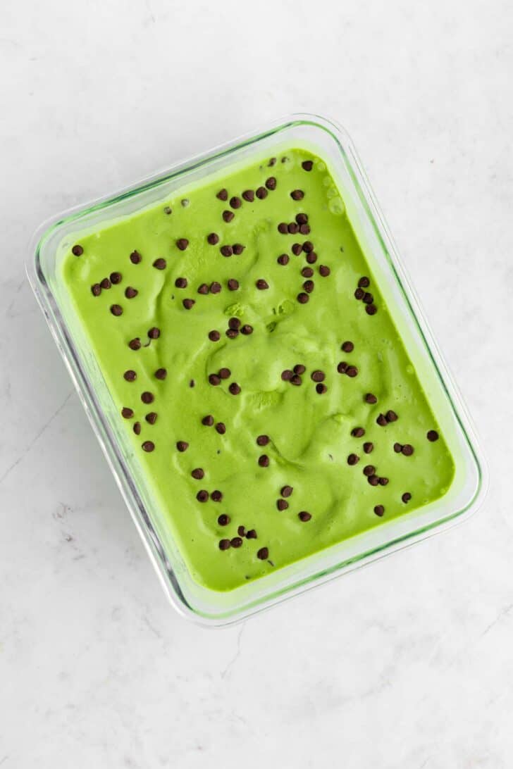 vegan matcha ice cream with chocolate chips inside a glass container