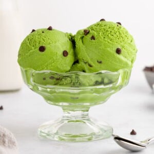 scoops of vegan matcha ice cream with chocolate chips inside a sundae glass