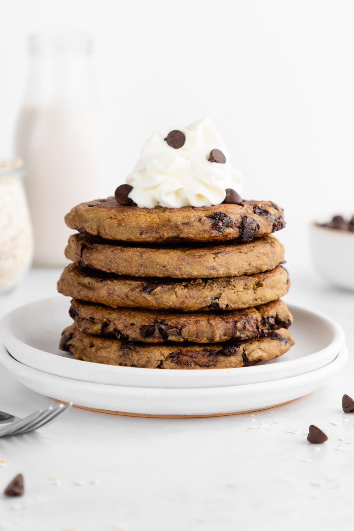 a stack of healthy oatmeal chocolate chip pancakes on a ceramic plate
