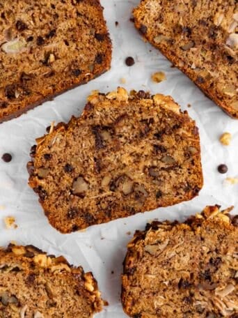 a close up of slices of chunky monkey banana bread with coconut, walnuts, and chocolate chips
