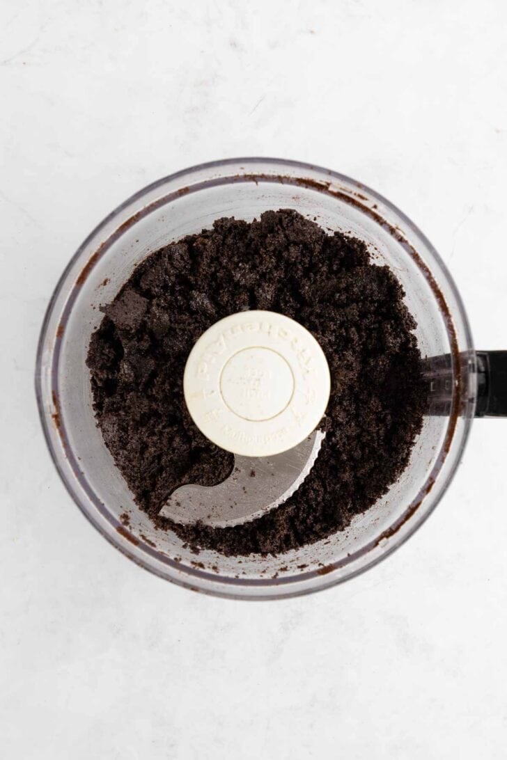 crushed Oreos and melted butter inside a food processor to make an Oreo crust