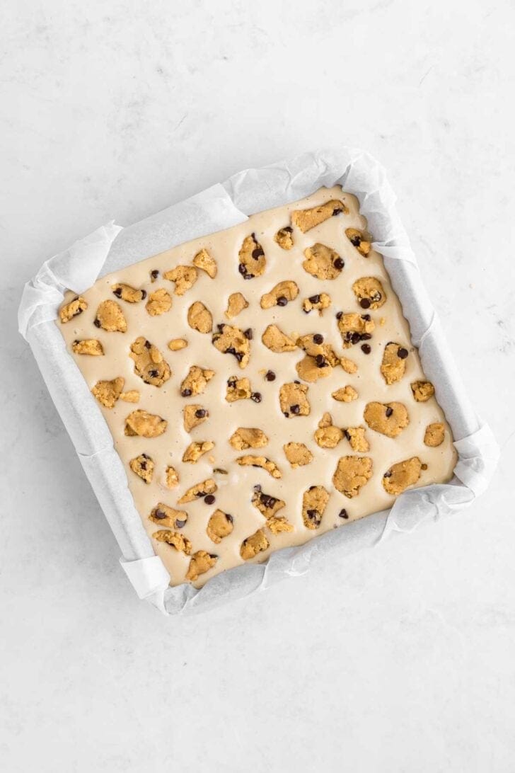 no-bake cookie dough cheesecake bars inside a square baking pan