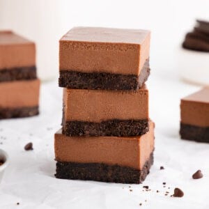 a stack of three no-bake chocolate cheesecake bars with an Oreo crust