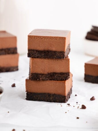 a stack of three no-bake chocolate cheesecake bars with an Oreo crust