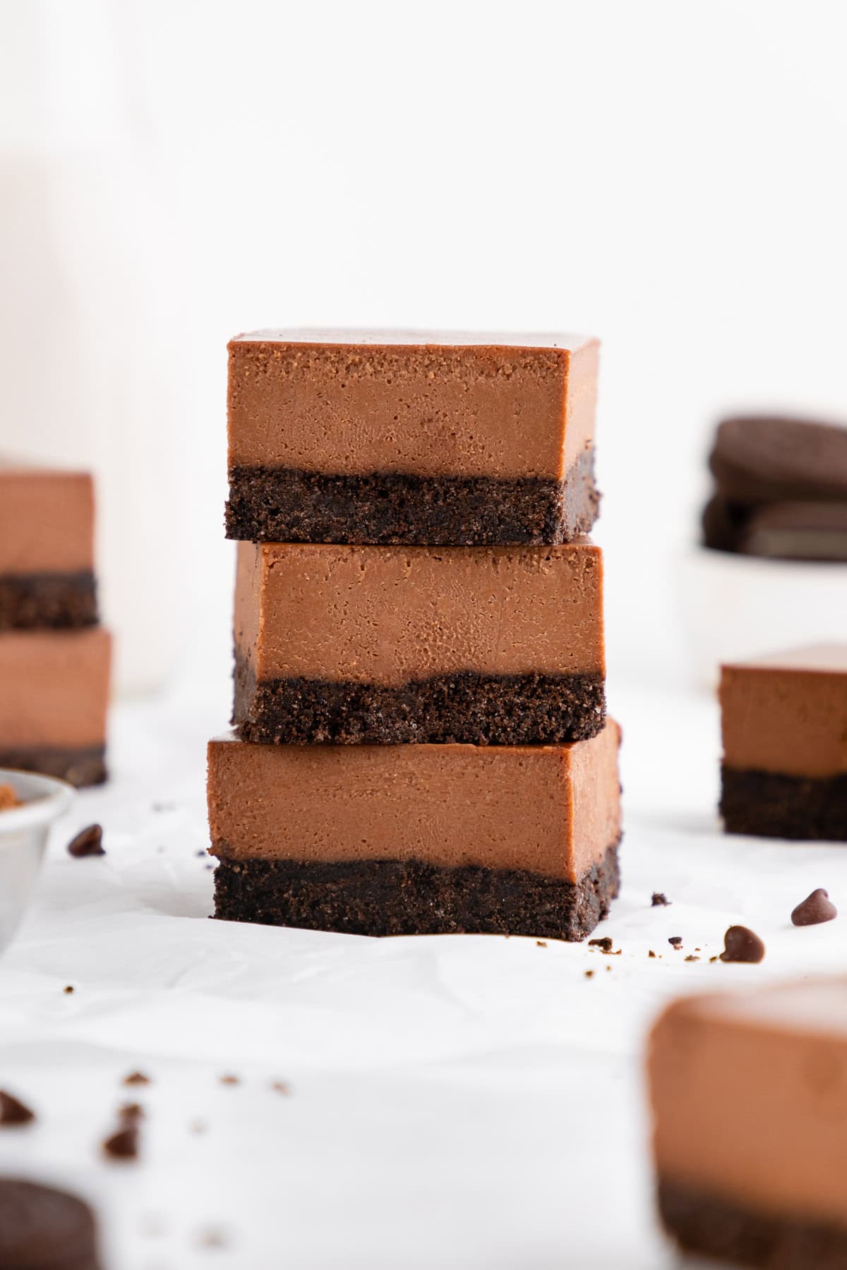 a stack of three no-bake chocolate cheesecake bars with an Oreo crust