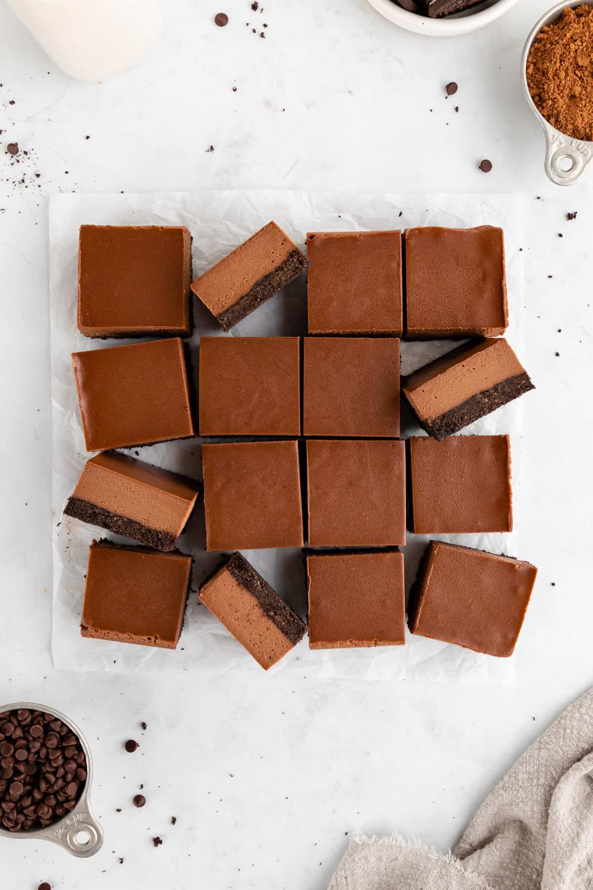 a pile of no-bake chocolate cheesecake bars with an Oreo crust