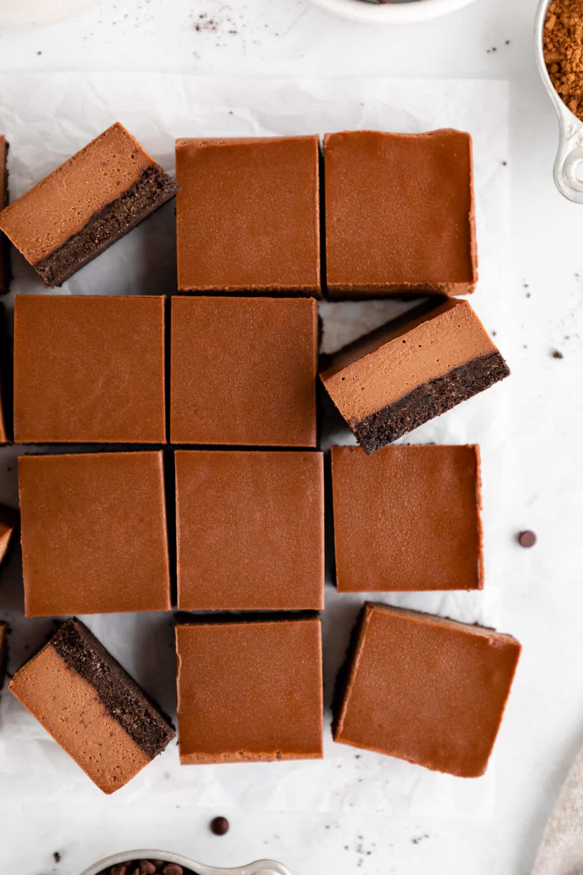 a close up pile of no-bake chocolate cheesecake bars with an Oreo crust
