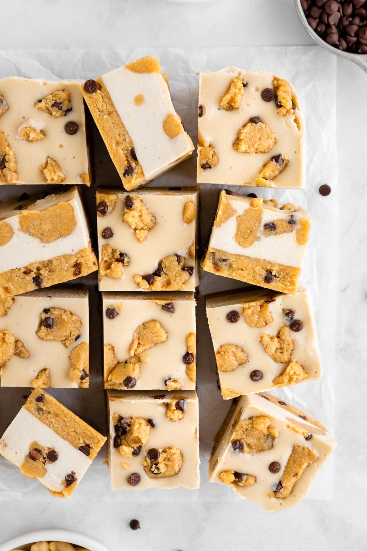 a pile of no-bake cookie dough cheesecake bars with coconut milk and cashews