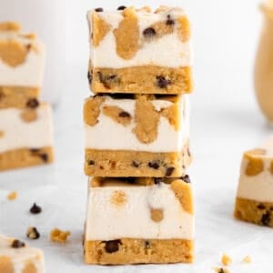 a stack of three no-bake cookie dough cheesecake bars